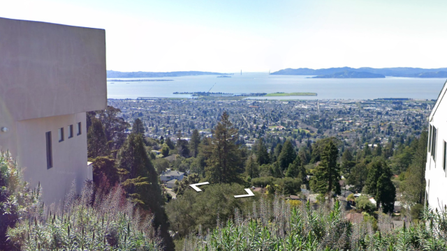 View from Hill Road looking over San Francisco Bay. A view from Berkeley Hills overlooking a city and bay with two white L-shaped markers in the foreground